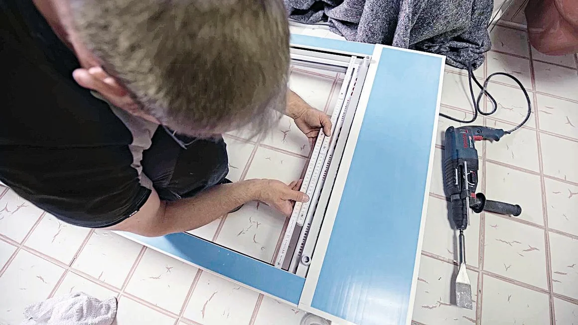 Person bringt ein Rollo an.